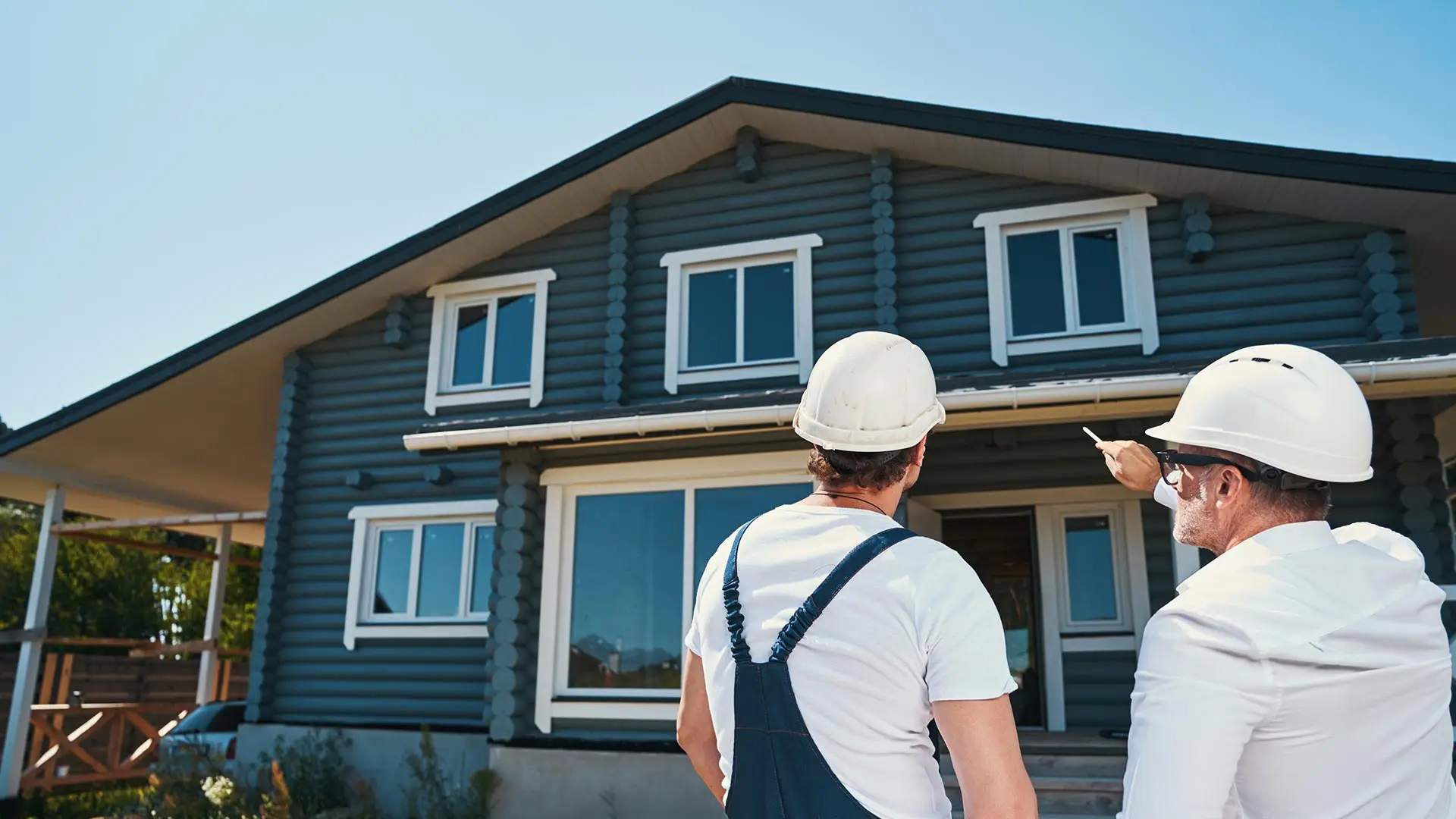 Two contractors looking at the roof of a home.