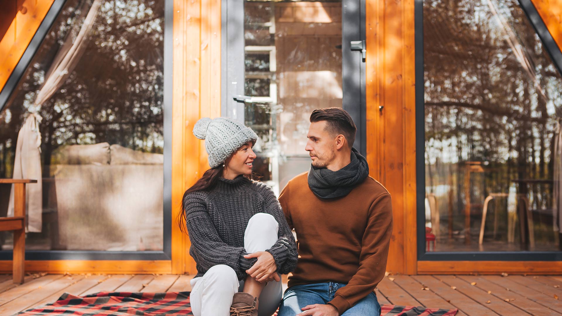 Man and woman in front of house with siding.