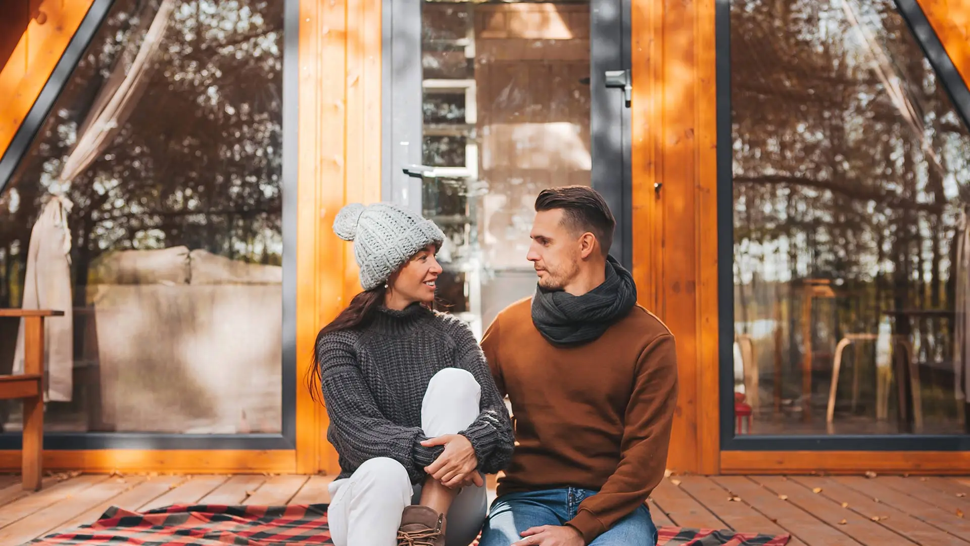 Man and woman in front of house with siding.