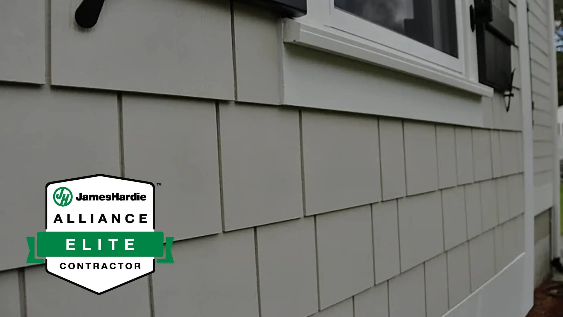 JamesHardie Alliance Elite Contractor badge over the shingles of a house.