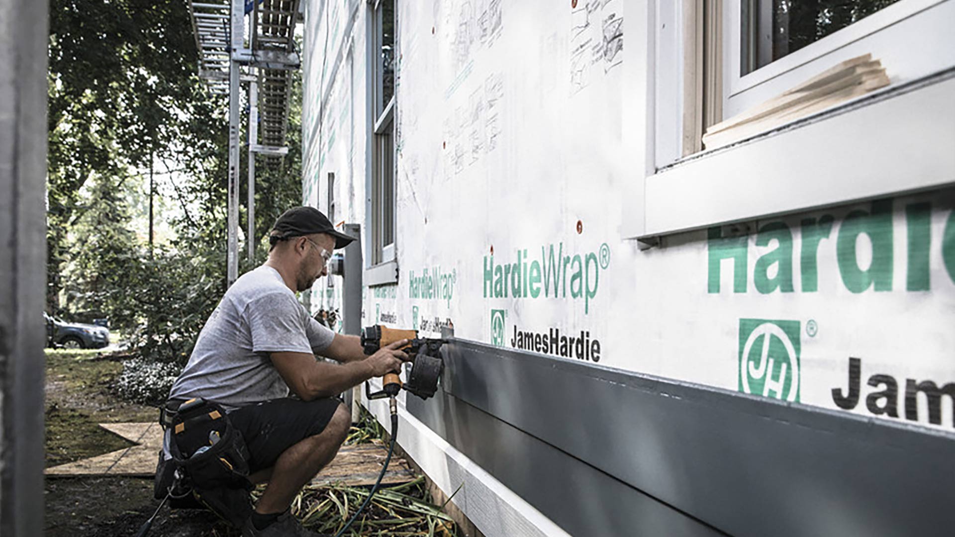 Siding installer putting siding on a house.