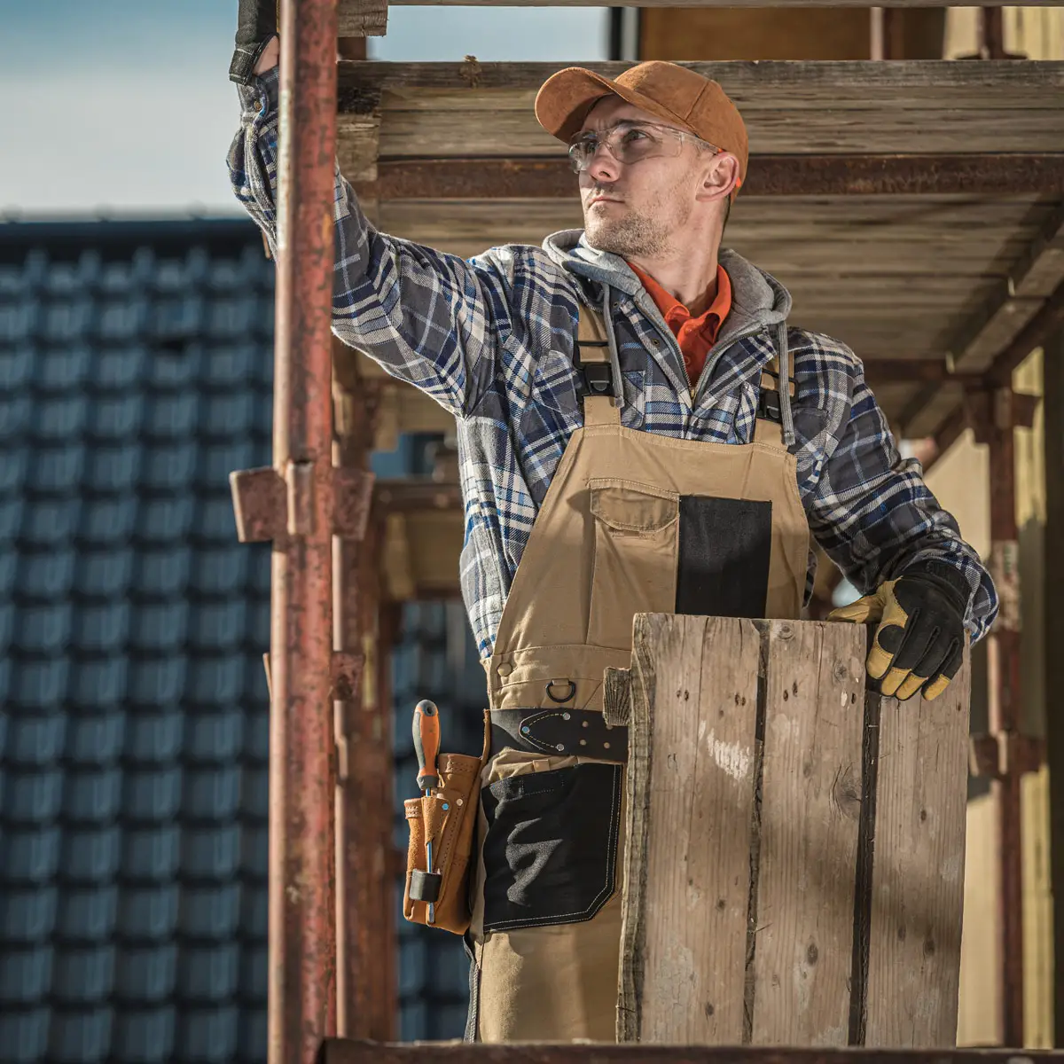 Male roofing worker looking at roof.